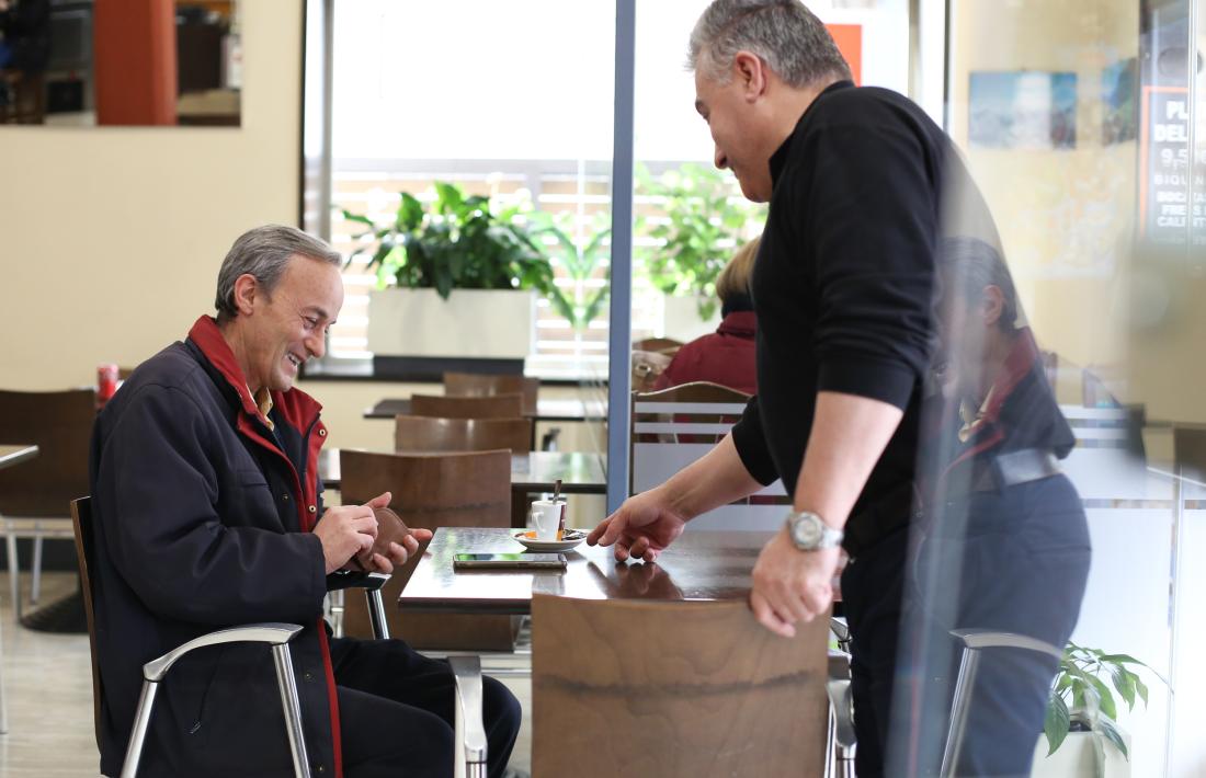 Candido Ferreira, per fi sense mascareta després de dos anys, serveix un cafè al seu establiment de la capital.