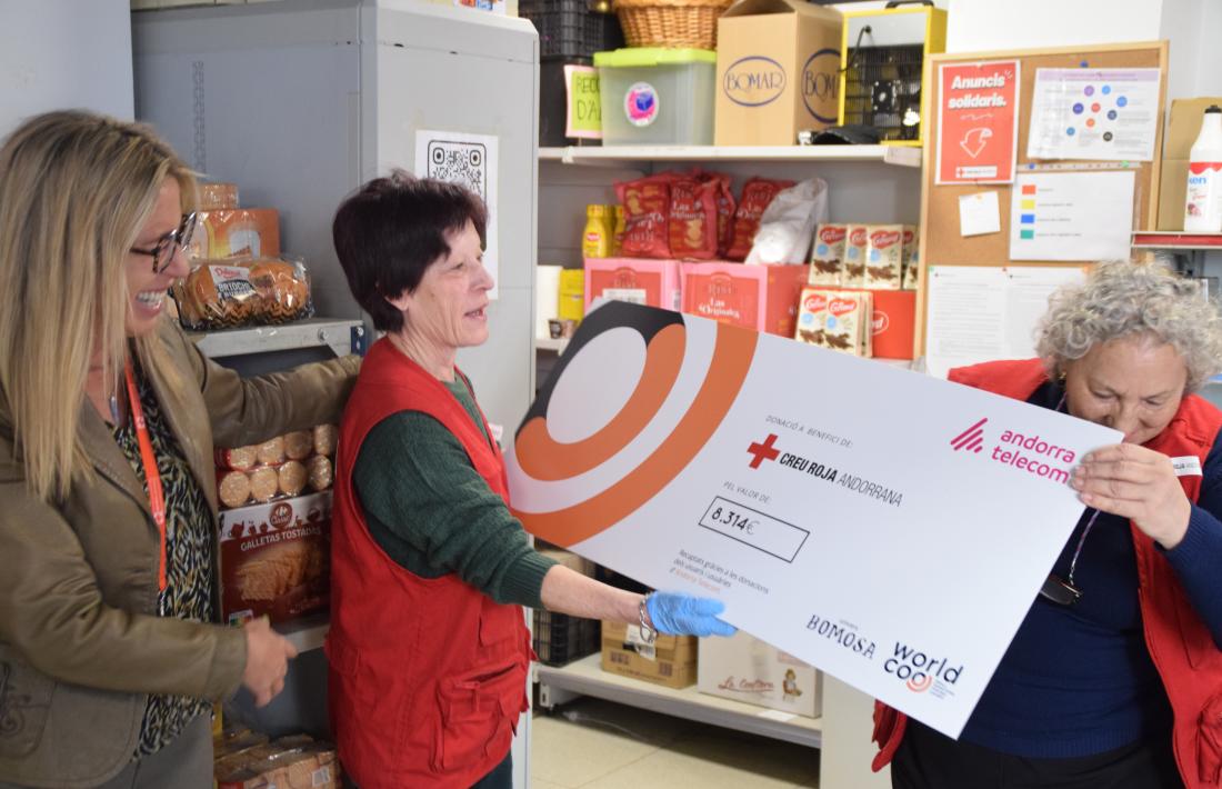 Anna Arias lliura el xec a dues col·laboradores de la botiga solidària.