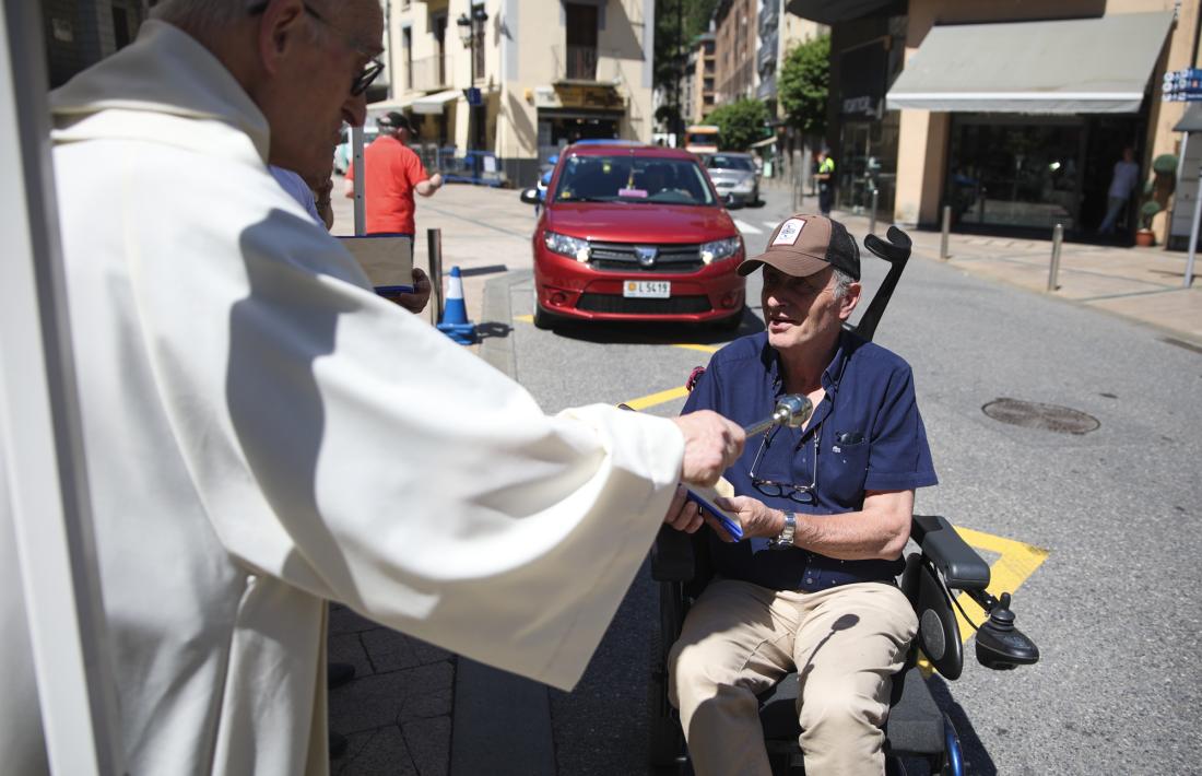 Una persona s'ha acostat amb la cadira de rodes per a que mossèn Sàrries la beneís.