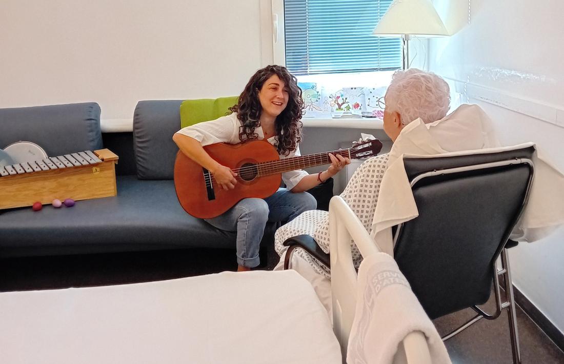 La musicoterapeuta Laia Font amb una pacient a l'hospital.