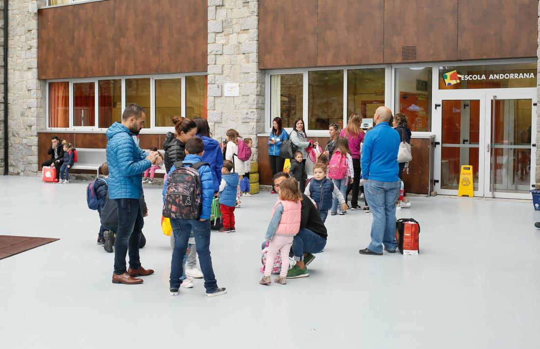 Alumnes acomanyats de familiars a la porta d'una escola.