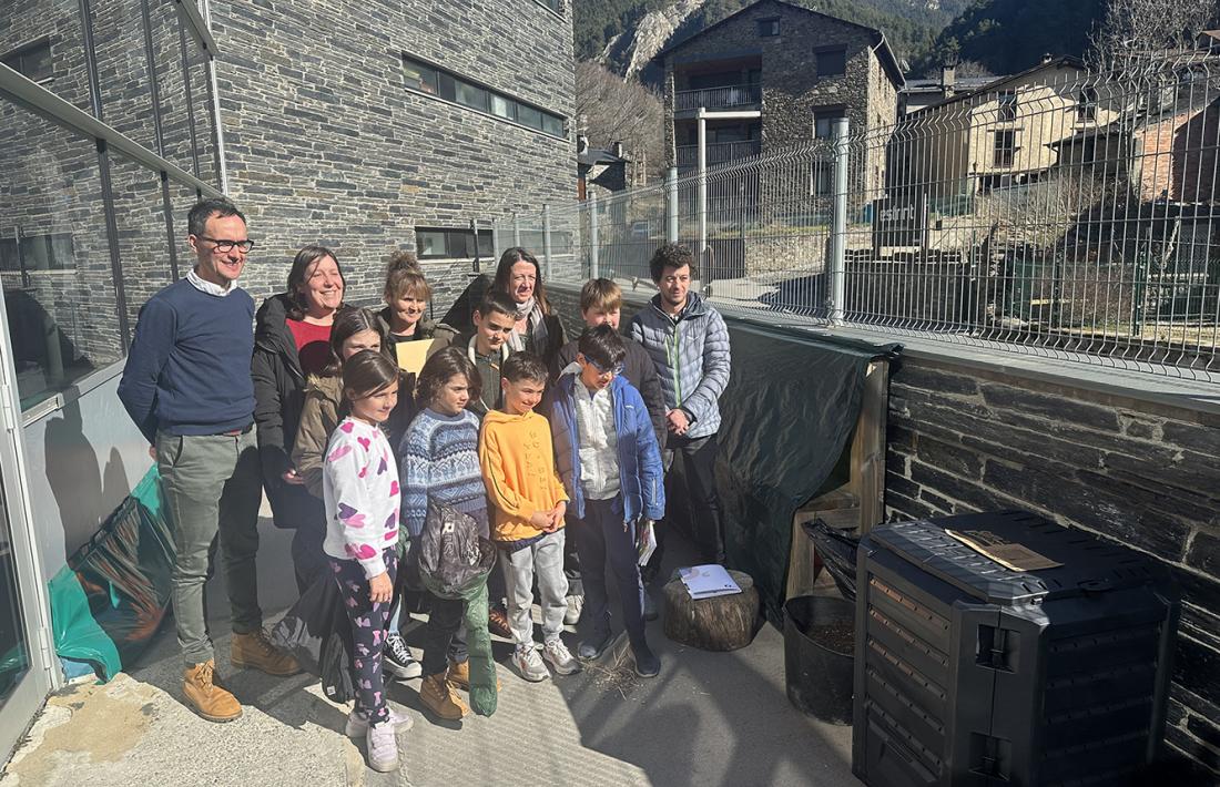 El grup d'infants, acompanyats de professors i responsables del Comú, que han rebut el compostador.